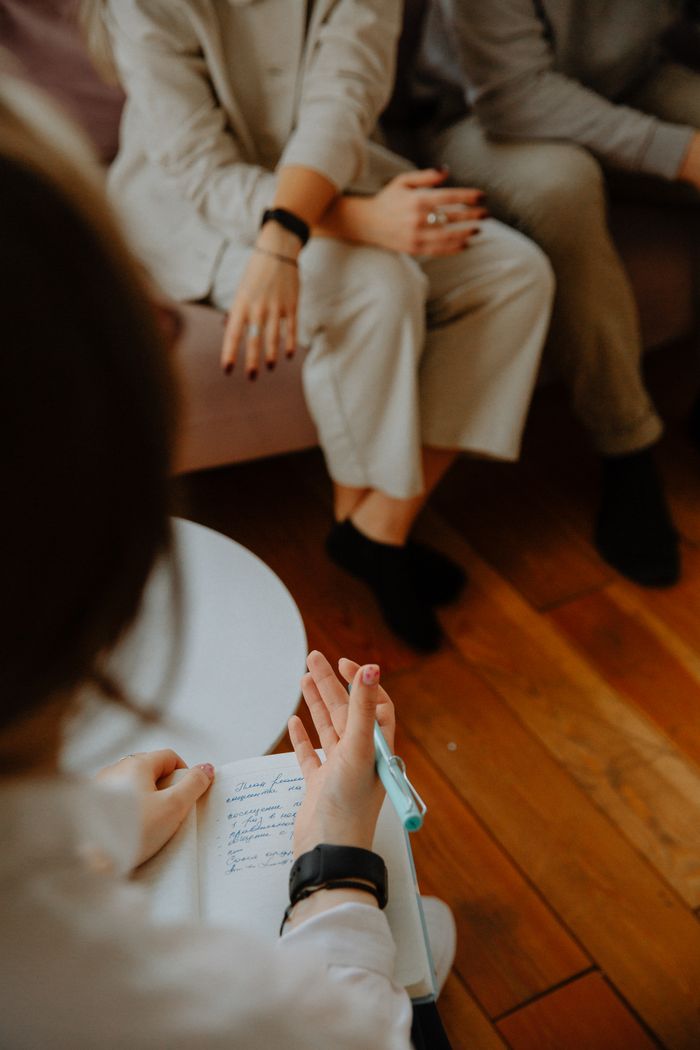 Services A therapy session with a counselor taking notes while clients discuss issues on a couch.