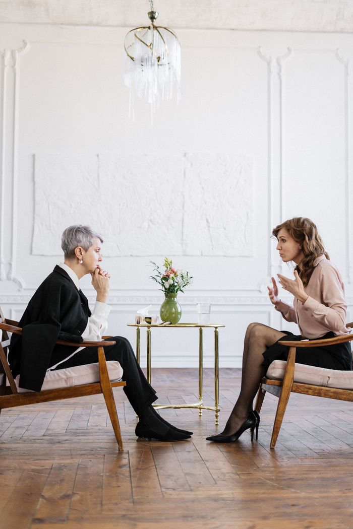 Mastering the First Impression: Your intriguing post title goes here Two women engaged in a counseling session in a bright, modern loft setting.